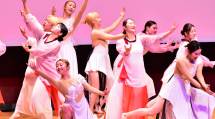 淡い色の衣装を着て、舞台上で創作ダンスを披露する天理大学創作ダンス部