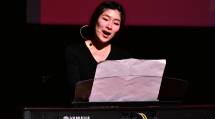 舞台上で歌唱指導しながらキーボードを演奏する北出はづき氏