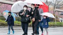 春の雨が降るなか、本部神殿へ向かう参拝者たち(3月26日)