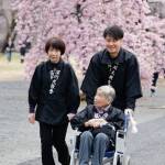 桜花爛漫の参道を通り、本部神殿へ向かう参拝者たち（3月26日）