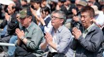 暖かな陽光に包まれるなか、祈りを捧げる参拝者たち（4月26日）