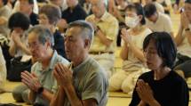 暑さ厳しいなか、一心に祈りを捧げる参拝者たち（7月26日）
