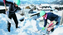 ２メートル近く積もった屋根の雪を、スコップで慎重に除去する隊員たち（２月３日、新温泉町多子地区で）